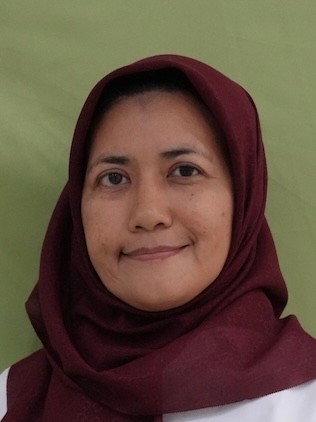 Portrait of a woman with a gentle, friendly smile against a solid green background. She looks directly at the camera.