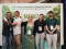 vor einer Konferenzwand mit dem Motto &bdquo;Towards Nature Positive Mangroves&ldquo;. Die Gruppe blickt l&auml;chelnd in die Kamera, einige haben sich freundschaftlich den Arm um die Schultern gelegt. 