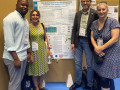 Vier Teilnehmende einer wissenschaftlichen Postersession stehen vor einem Forschungsplakat w&auml;hrend einer Mangrovenforschungskonferenz. 