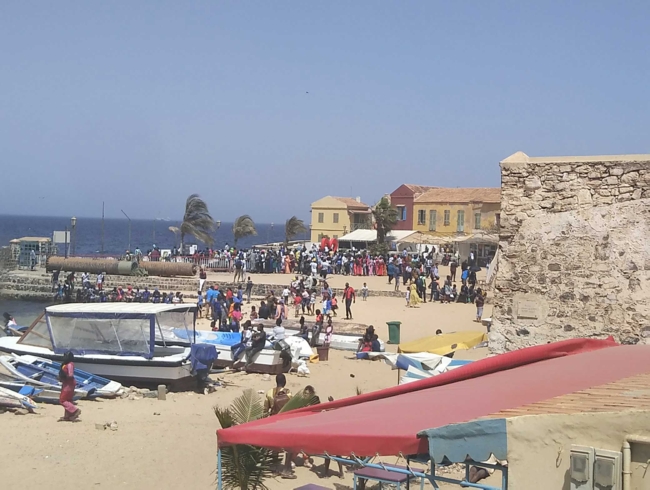 People and boats on the beach in a coastal town in Senegal